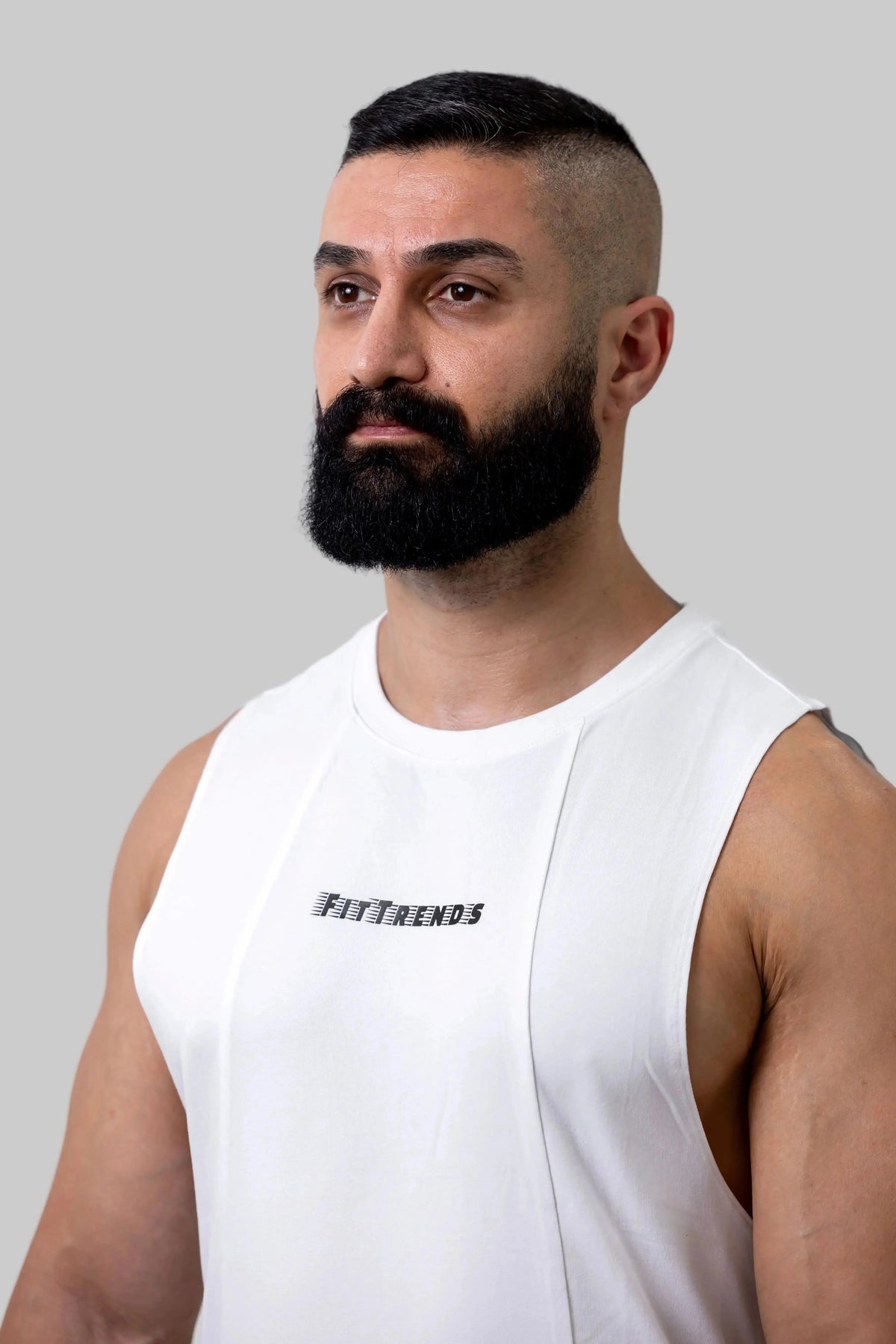 Man wearing a white sleeveless shirt with 'FitFriends' logo against a plain background