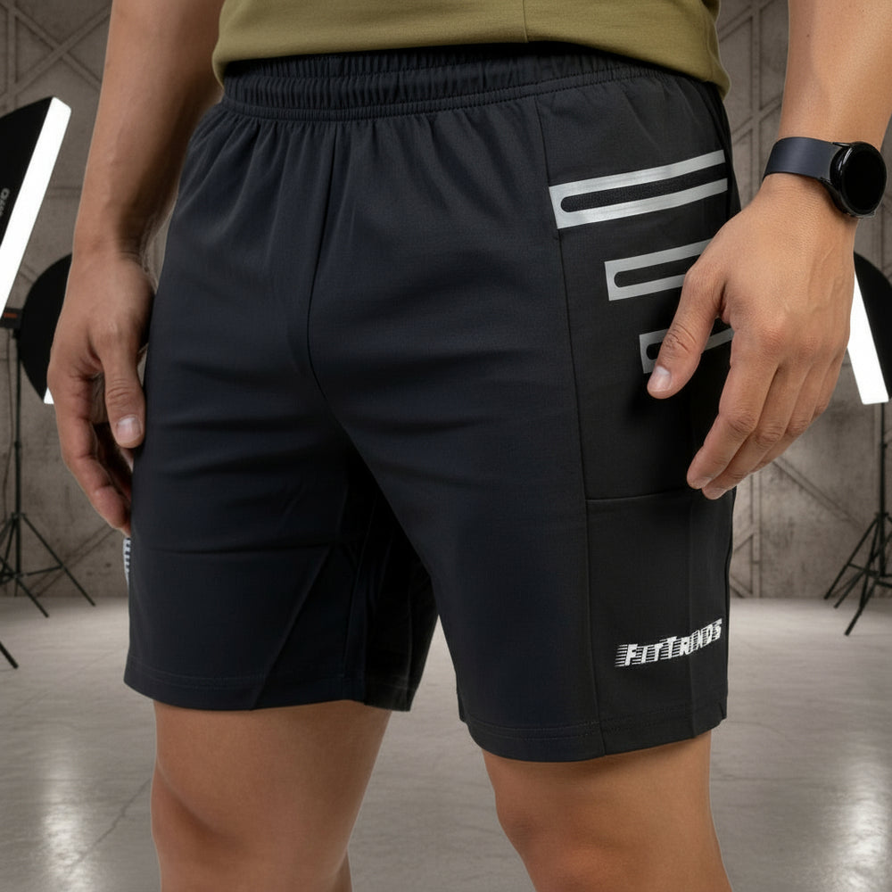 Person wearing black shorts with white branding and an olive green sleeveless top on a white background