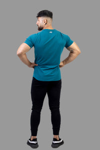 Man wearing a teal athletic shirt and black leggings on a white background