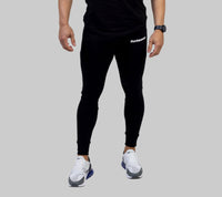 Person wearing black athletic pants with a brand logo on a white background