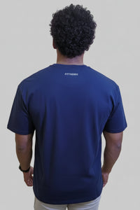 Person wearing a navy blue t-shirt with 'Fittrends' branding on the back, standing in front of a wall with large pink letters.