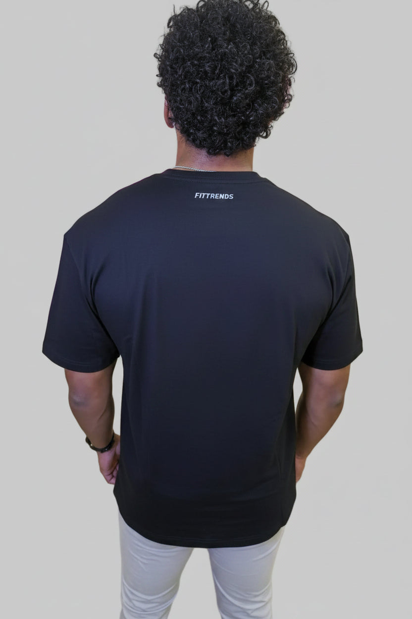 Person wearing a black t-shirt with 'Fittrends' logo in front of a wall with large pink letters.