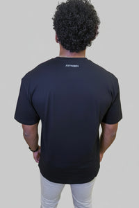 Person wearing a black t-shirt with 'Fittrends' logo in front of a wall with large pink letters.