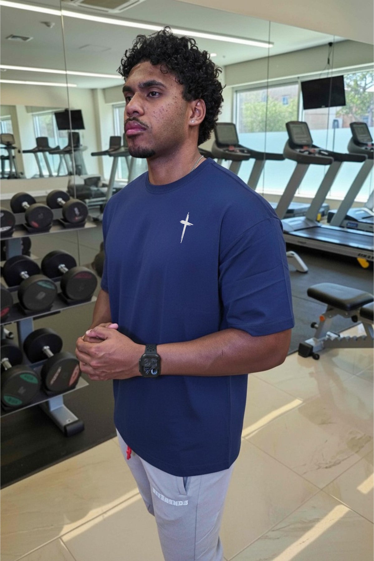 Man in a gym wearing a blue shirt with a logo