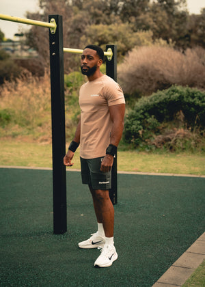 Man exercising outdoors on a green surface with trees in the background