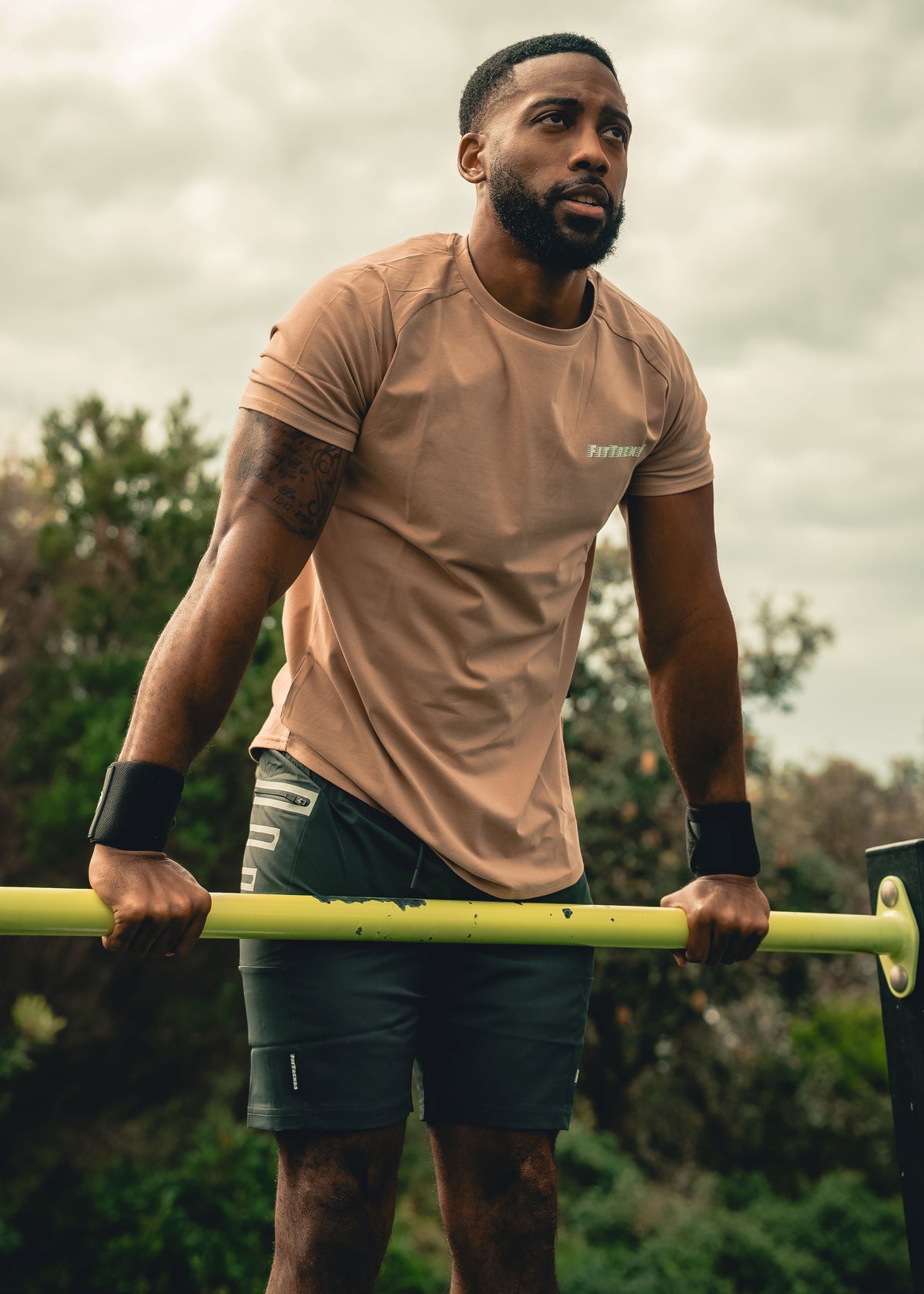 Man exercising on a pull-up bar outdoors with a natural background