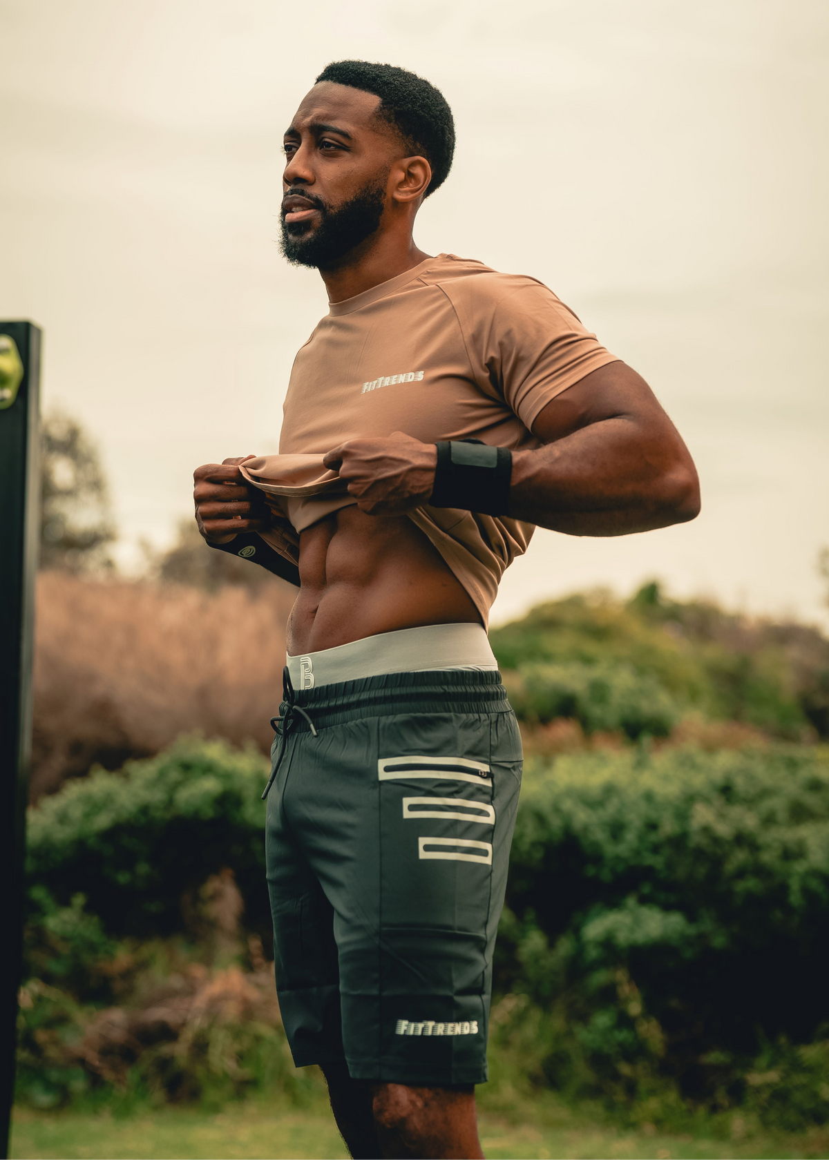 Man in athletic wear standing outdoors with a blurred background