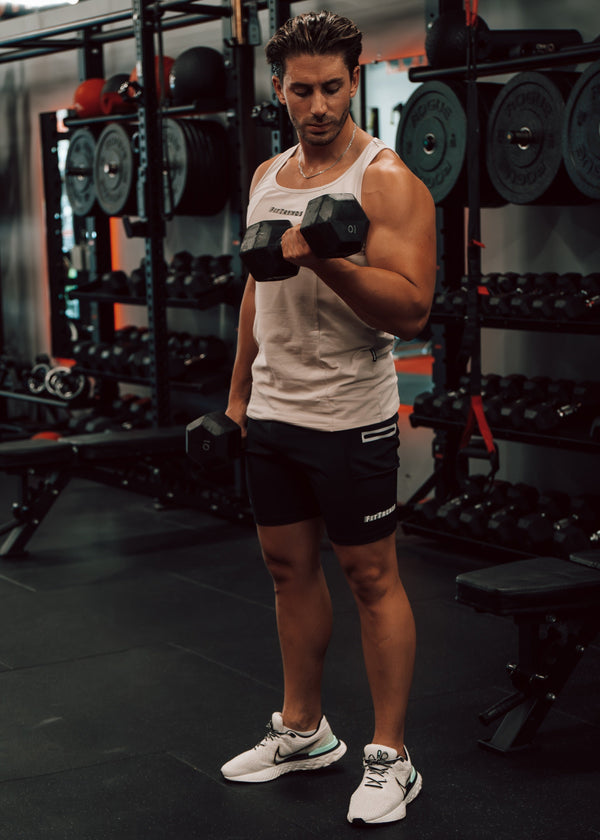 Man lifting dumbbells in a gym setting