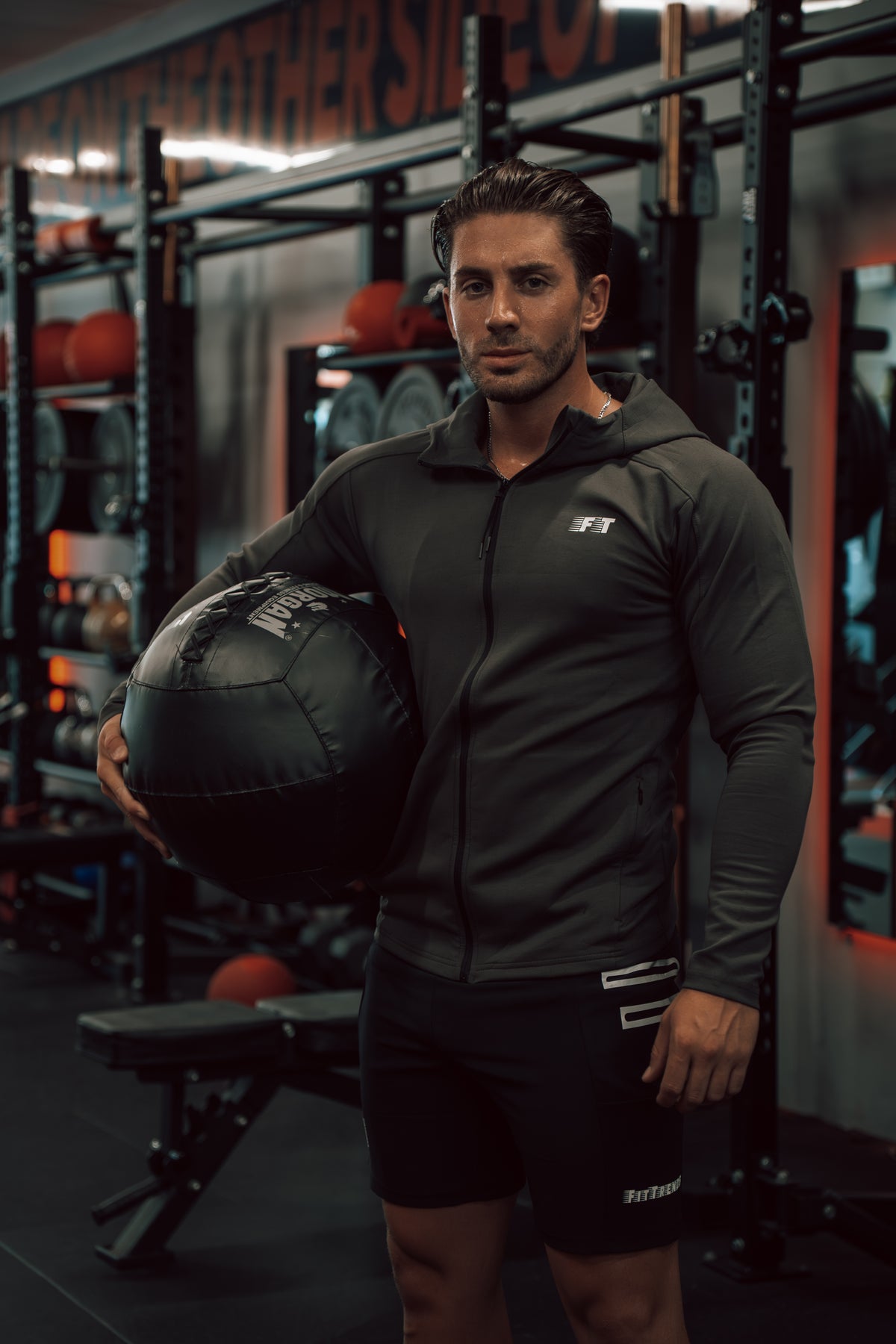 Man holding a medicine ball in a gym setting