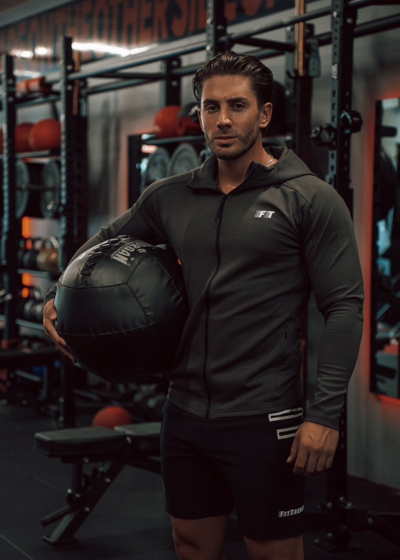 Man holding a medicine ball in a gym setting