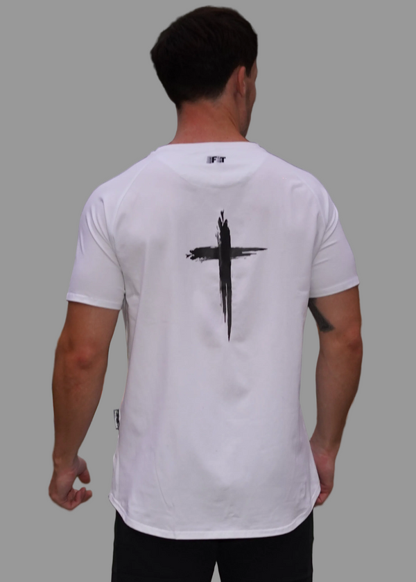 Person wearing a white t-shirt with a black cross design on the back, standing outdoors.