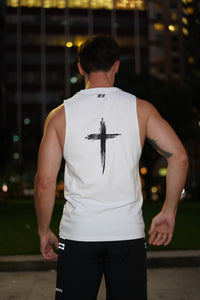 Person wearing a white tank top with a black design on the back, standing outdoors at night.