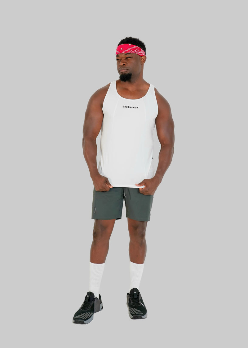 Man wearing a white tank top and gray shorts on a white background