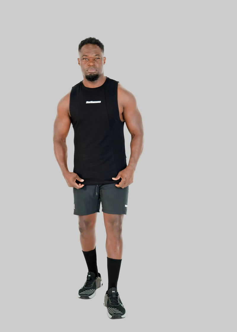 Man wearing a black sleeveless shirt and gray shorts on a white background