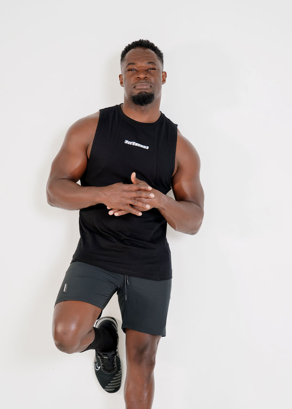 Man wearing a black sleeveless shirt and shorts on a white background