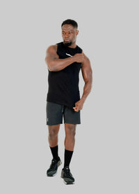 Man wearing a black sleeveless shirt and shorts on a white background