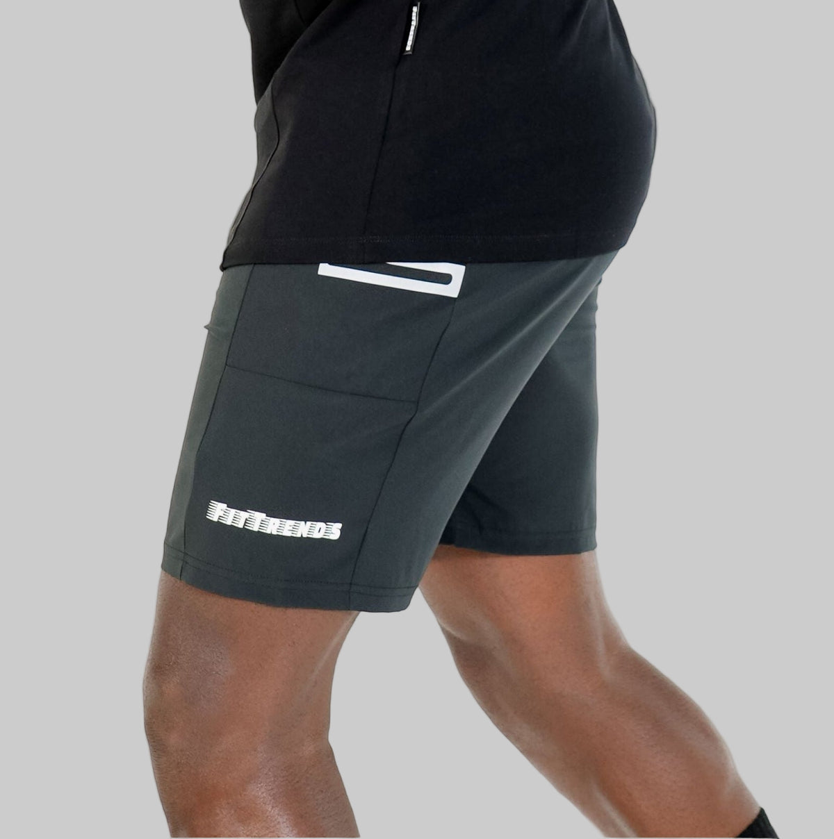 Man wearing black athletic outfit with visible brand logo on a white background