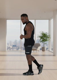 Man in black athletic wear standing against a white background