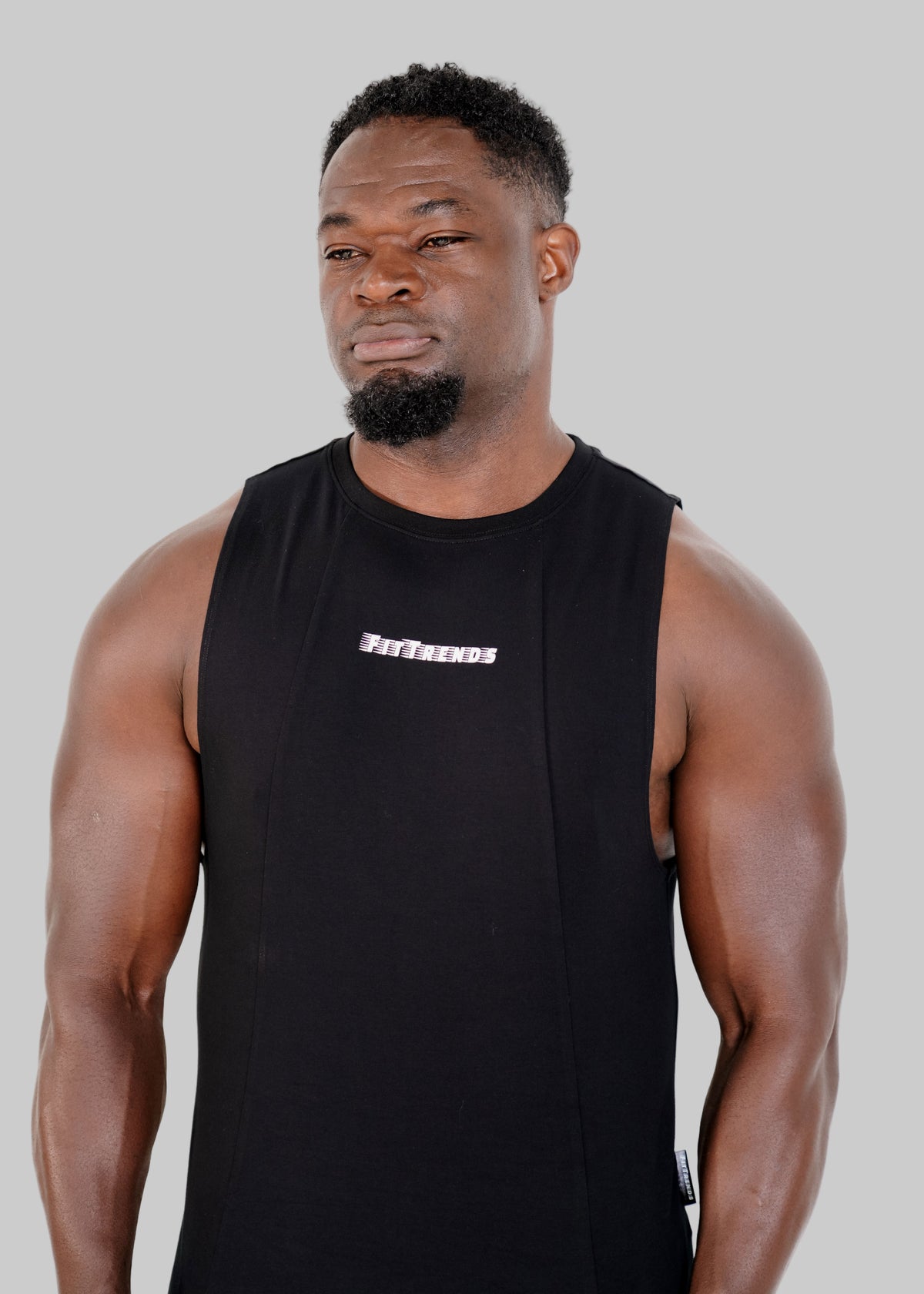 Man wearing a black sleeveless shirt with a logo on a white background