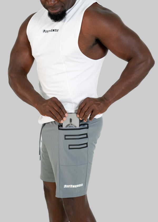 Person wearing a white tank top and gray shorts with branding on a white background