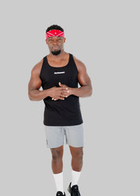 Man wearing a black tank top and gray shorts with a red bandana on a white background