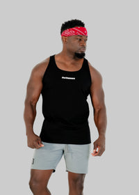Man wearing a black tank top with visible branding and light gray shorts on a white background