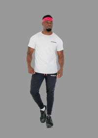 Man wearing a white t-shirt, black pants, and black sneakers on a white background