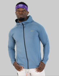 Person wearing a blue athletic jacket and white pants on a white background