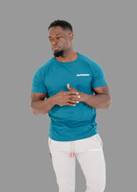 Man wearing a teal t-shirt with a logo on a white background
