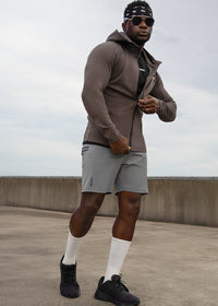 Man in athletic wear standing on a rooftop with a cloudy sky background