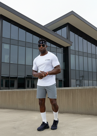 Man in athletic wear standing in front of a modern building