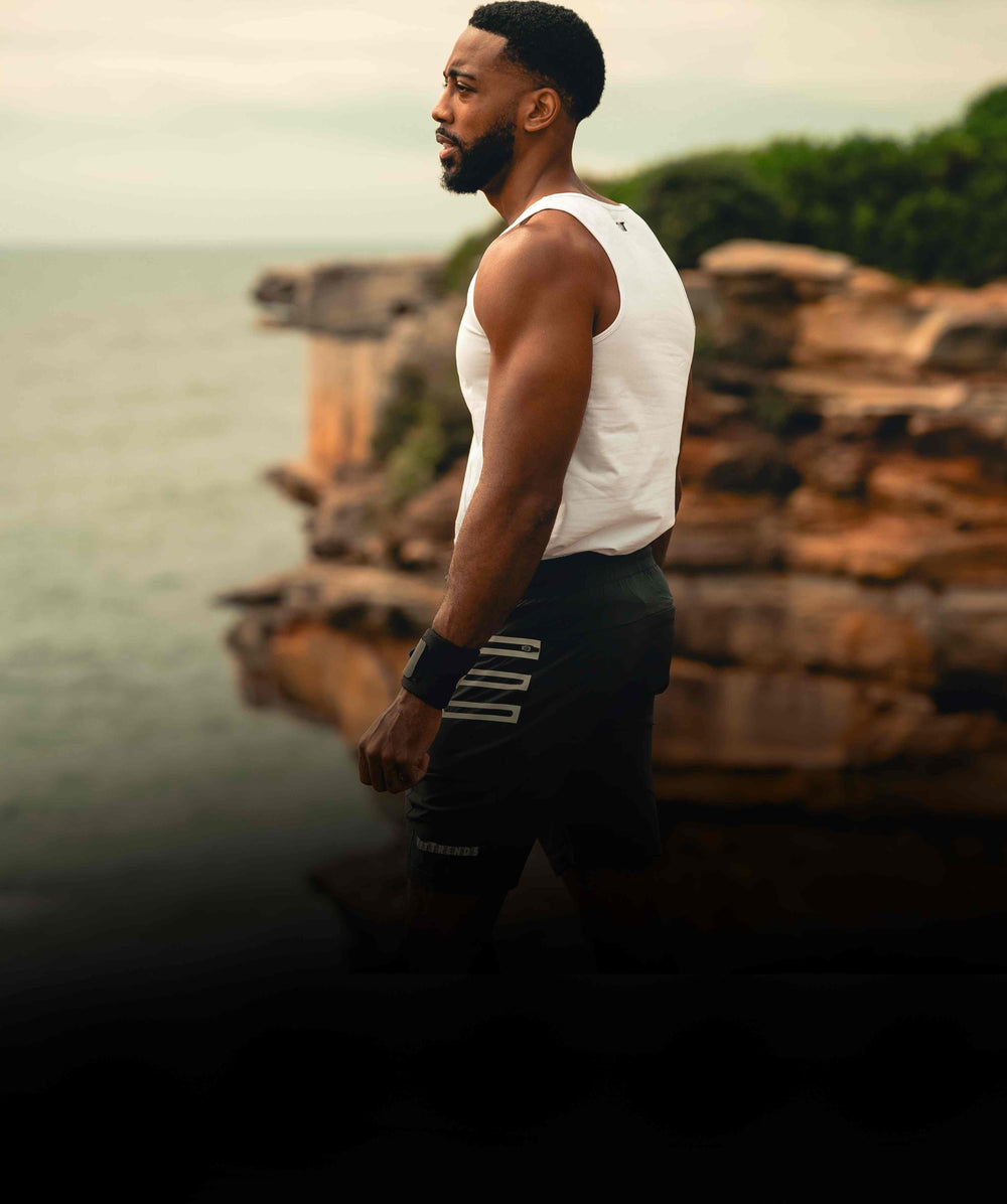 Man standing by a body of water with a scenic background