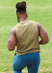 Person walking on a grassy area with a metal surface in the foreground