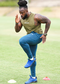 Person in athletic wear performing a movement on a grassy field