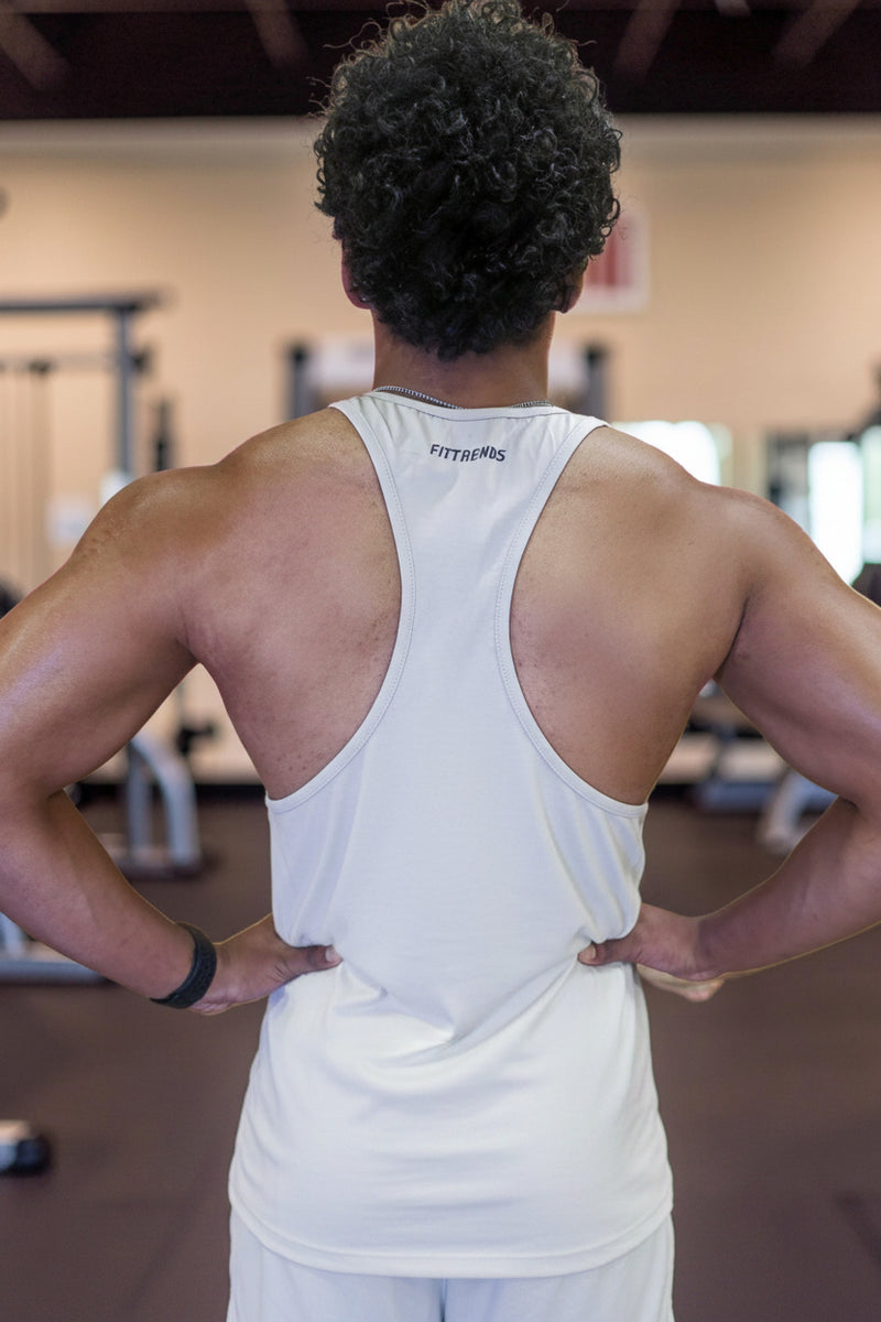 Person wearing a white tank top with visible branding in a gym setting
