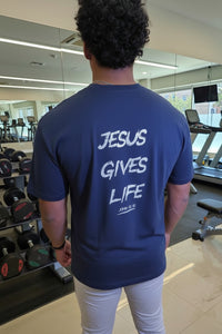 Person wearing a blue t-shirt with 'Jesus Gives Life' text in a gym setting