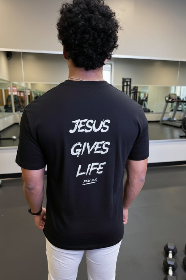 Person wearing a black t-shirt with 'Jesus Gives Life' text in a gym setting